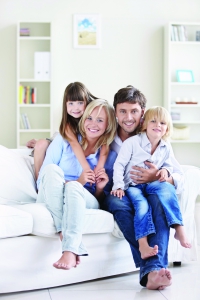 A happy family with children on a white sofa at home